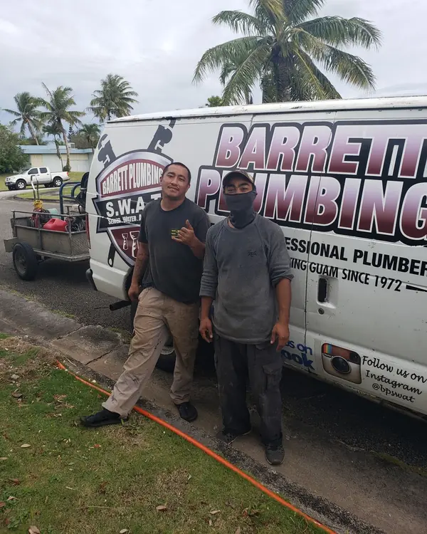 Two Barrett crew members standing in front of a Barrett Plumbing van lettered 'Since 1972'