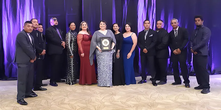 The Barrett team in formal wear at a Chamber of Commerce awards night, with Jessica Barrett in the middle holding the award plaque
