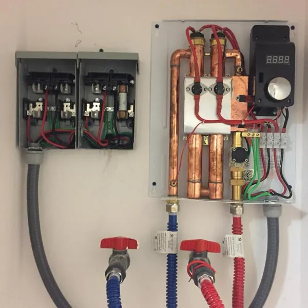 Tankless electric water heater installed by Barrett, with copper lines and red shut-off valves